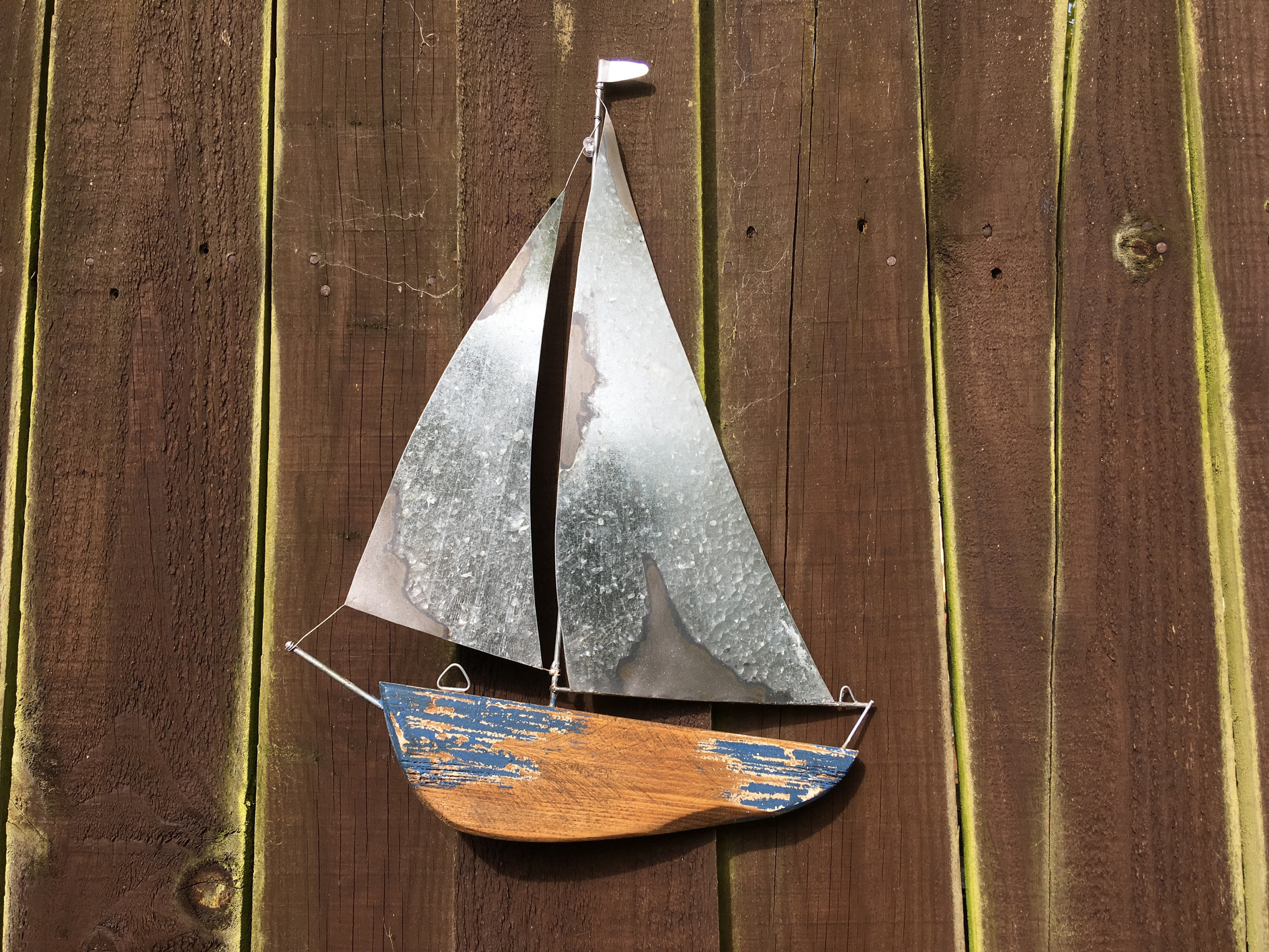 tin and wooden sail boat wall art